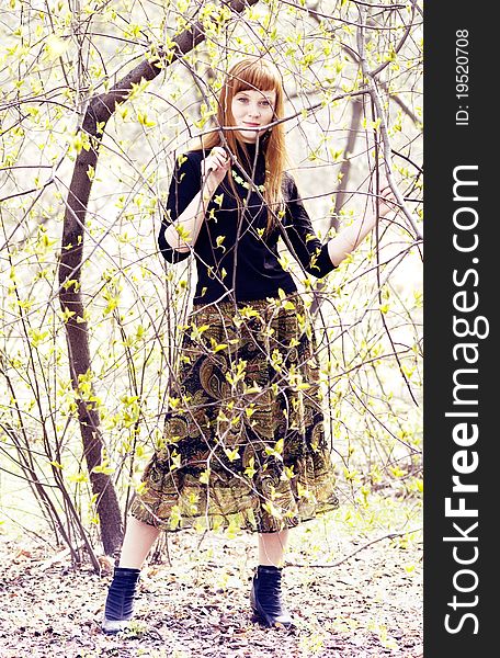 Full length portrait of a beautiful young woman among tree branches. Full length portrait of a beautiful young woman among tree branches