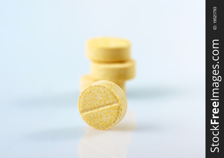 Isolated yellow pills on white