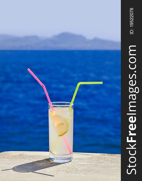 Cocktail on marble table at beach - travel background
