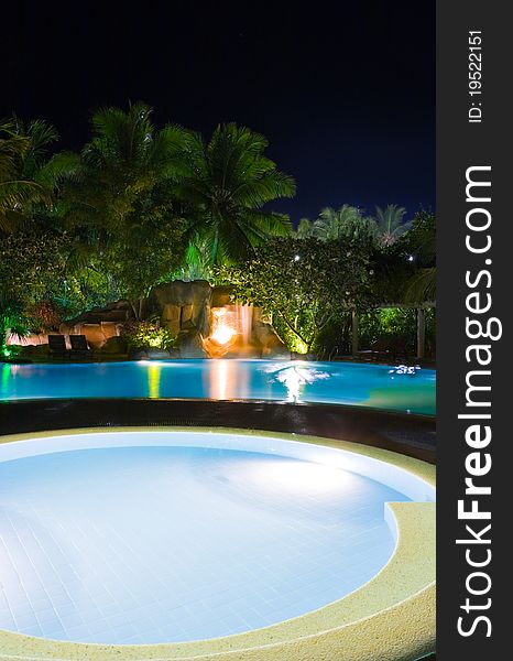 Pool and waterfall at night - vacation background