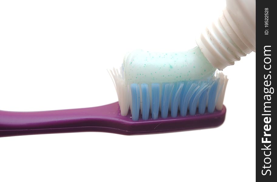 Closeup of a toothbrush and toothpaste isolated on a white background