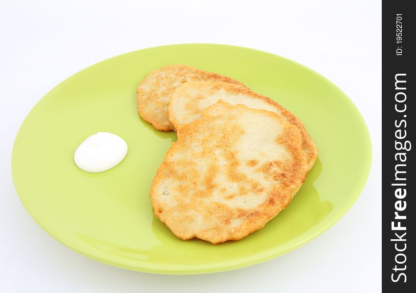 Potato pancakes with cream on white background