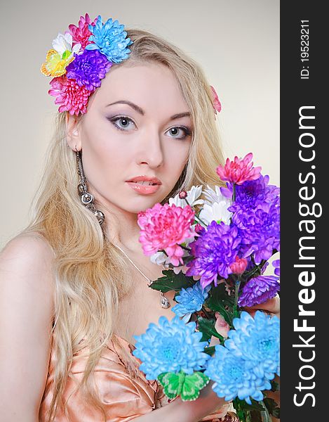 Beautiful young woman with colorful flowers in hair
