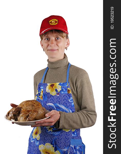 The young woman holds a plate with a roast chicken. The young woman holds a plate with a roast chicken.