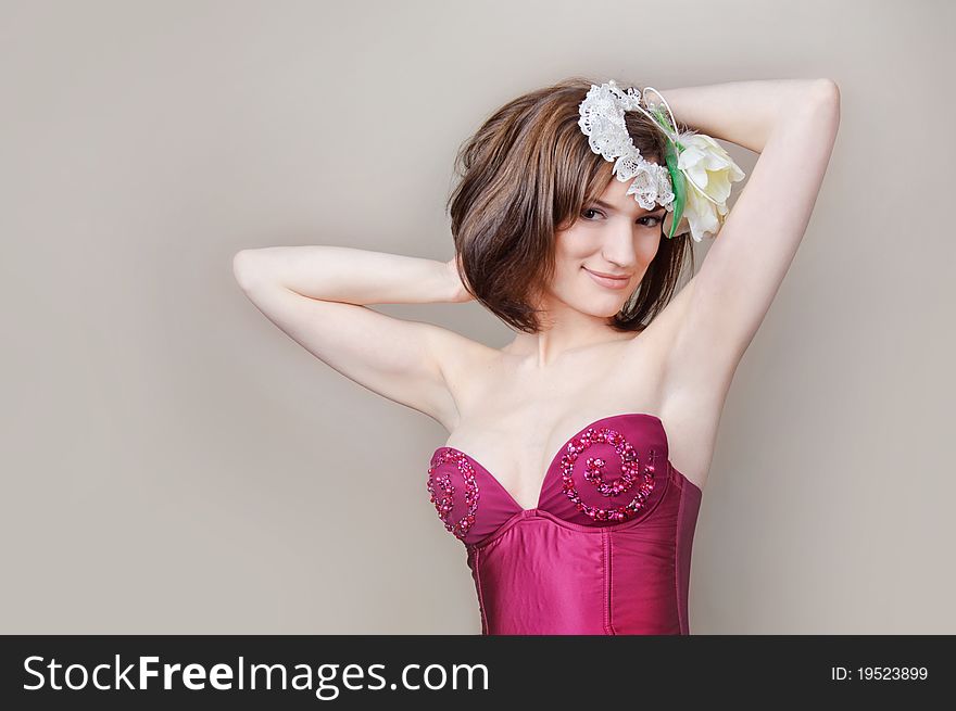 Beautiful young woman in a red dress with white flowers on her head