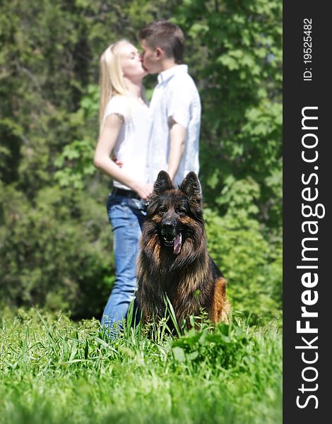 Young loving couple with dog outdoors