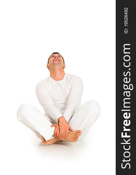 Man dressed in white sitting on the floor in white background