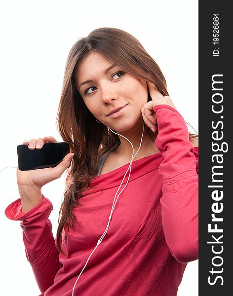 Happy young woman listening, enjoying music and holding cellular mp3 player in earphones on top of her head wearing dance pink top, isolated on white background. Happy young woman listening, enjoying music and holding cellular mp3 player in earphones on top of her head wearing dance pink top, isolated on white background