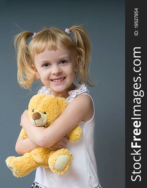 Little girl hugging a teddy bear and smiling. Little girl hugging a teddy bear and smiling