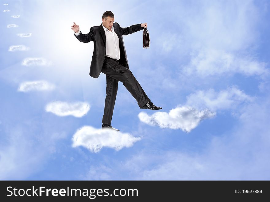 The businessman cautiously walks on unstable cloudy steps of financial business. The businessman cautiously walks on unstable cloudy steps of financial business