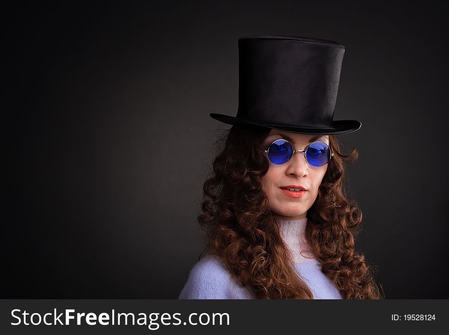 Pretty woman in blue spectacles and a black hat