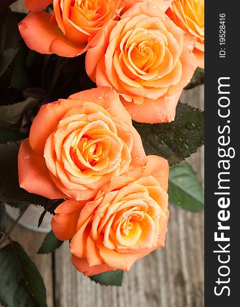 Top view on bunch of orange roses on old wooden table