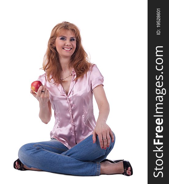 Tall mature woman in jeans sit with apple isolated. Tall mature woman in jeans sit with apple isolated