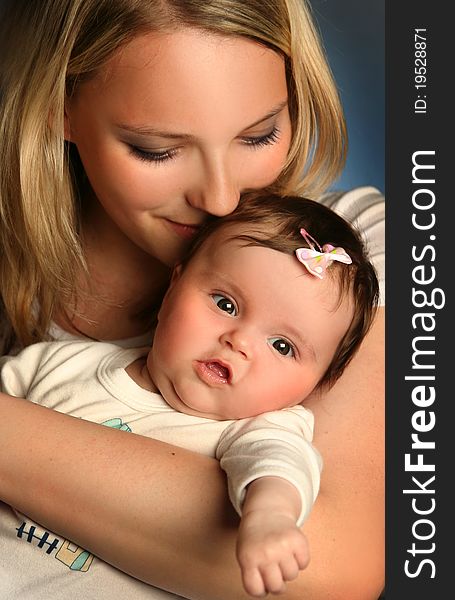 Young mother with baby on blue background. Young mother with baby on blue background