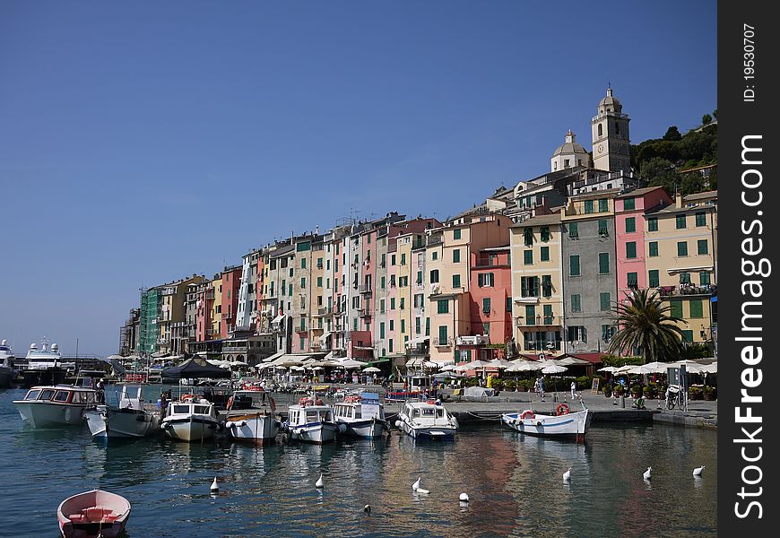 Calata Doria, in Portovenere, from the harbor, in a sunny day with reflections of the buildings in the water. Calata Doria, in Portovenere, from the harbor, in a sunny day with reflections of the buildings in the water