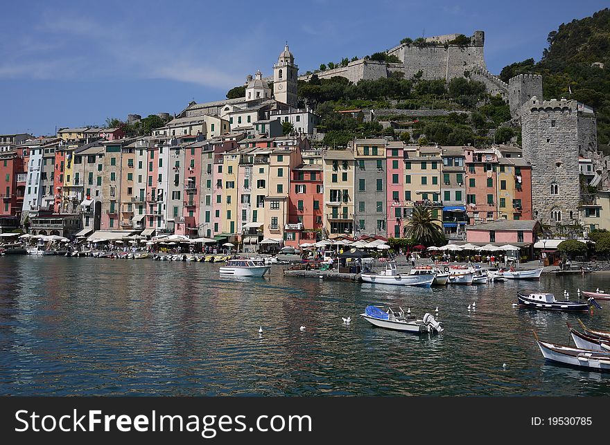 The harbor and the medieval towers of the Ligurian village in a sunny day. The harbor and the medieval towers of the Ligurian village in a sunny day