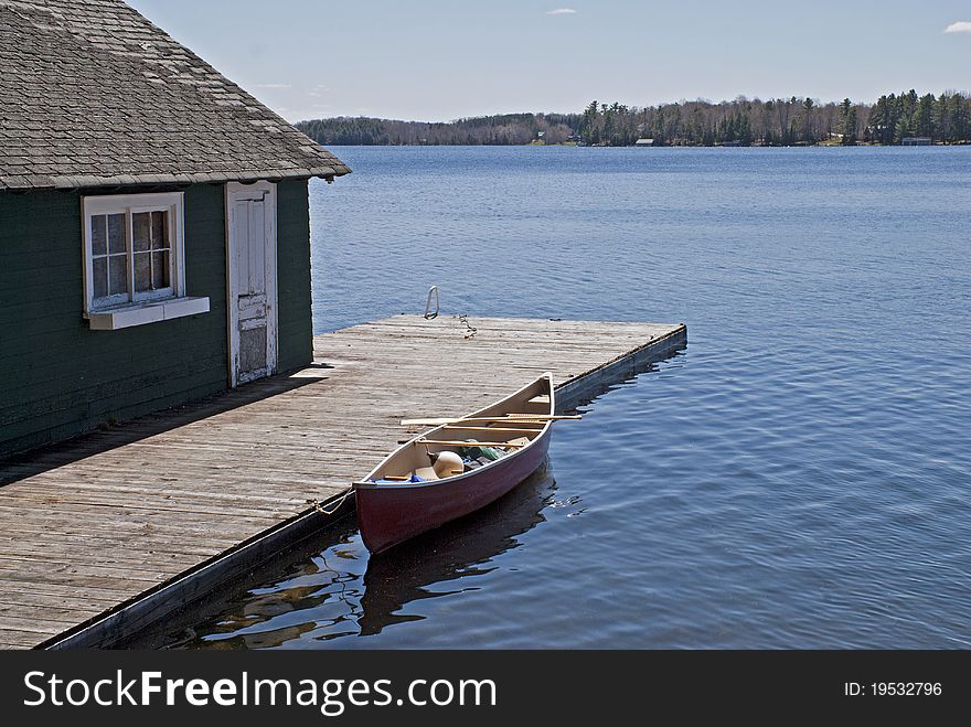 Canoe on Lake Rousseau with boat house, Ontario, Canada. Canoe on Lake Rousseau with boat house, Ontario, Canada