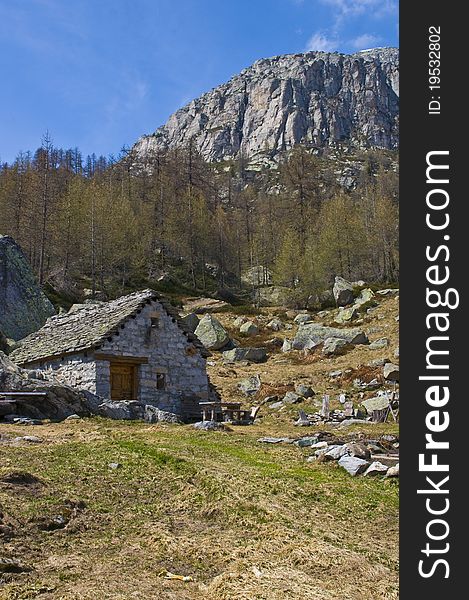 A traditional old chalet make in stone in a mountain landscape. A traditional old chalet make in stone in a mountain landscape