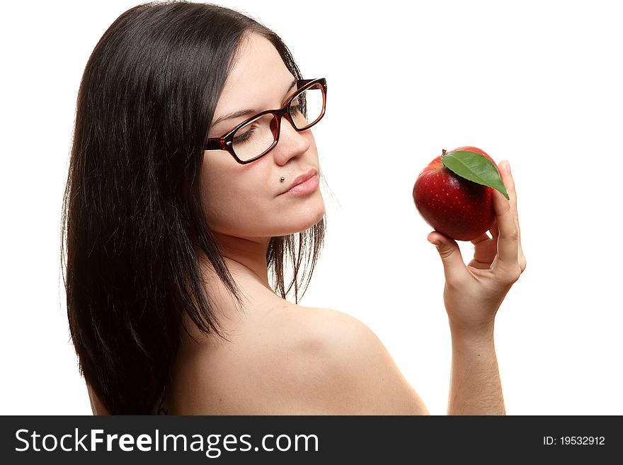The beautiful girl wearing spectacles with an apple in a hand on a white background