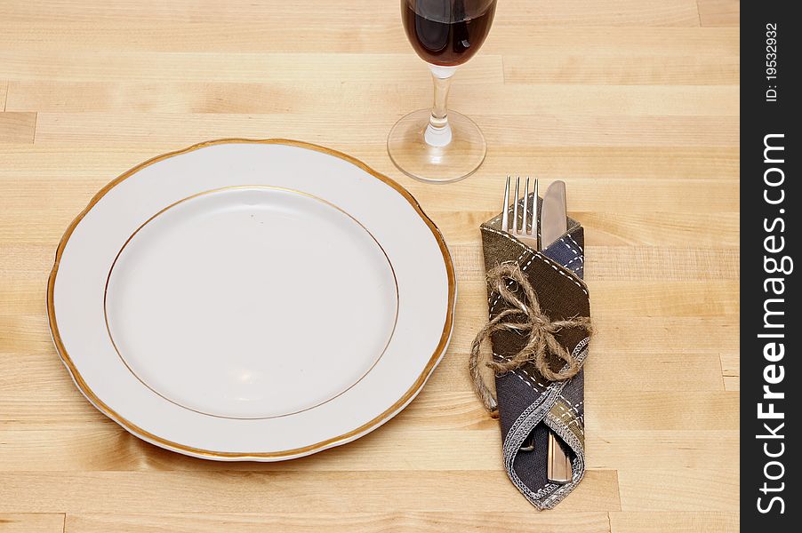 Knife and fork in textile napkin on wooden table