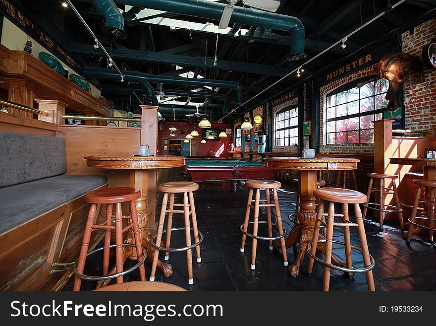 Typical irish pub with bar stools, pool tables, and a rustic feel.