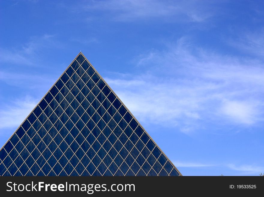 Top of blue glass building with pyramid shape. Top of blue glass building with pyramid shape.