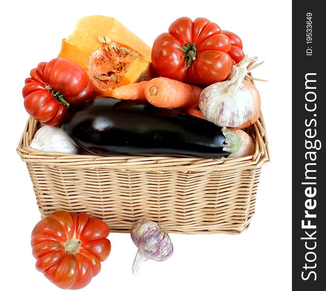 Ripe fresh vegetables in wicker basket isolated on white