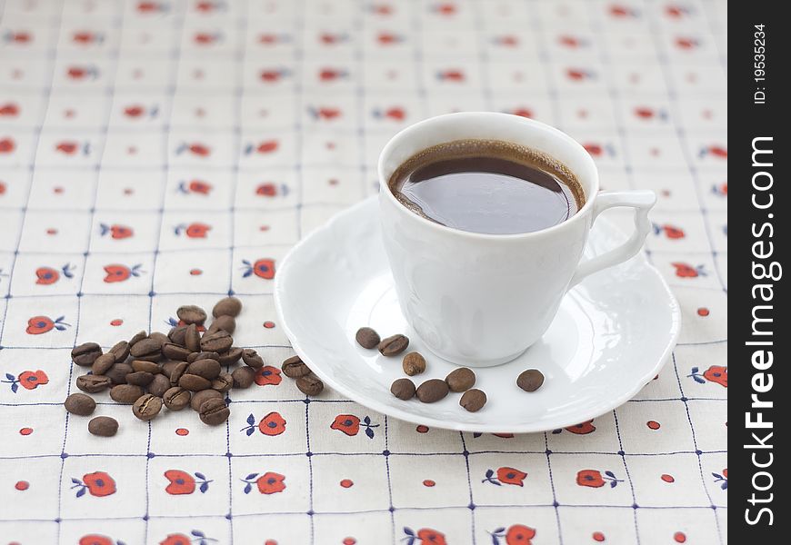 Cup of coffee and coffee beans on the table