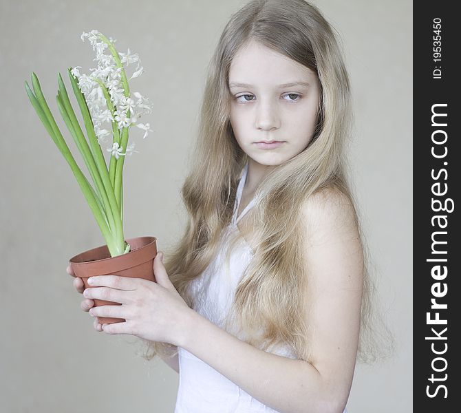 A young girl holding a pot of flowers