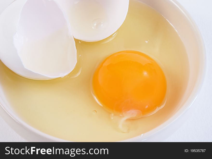 Broken chicken egg and yolk on a saucer. Broken chicken egg and yolk on a saucer
