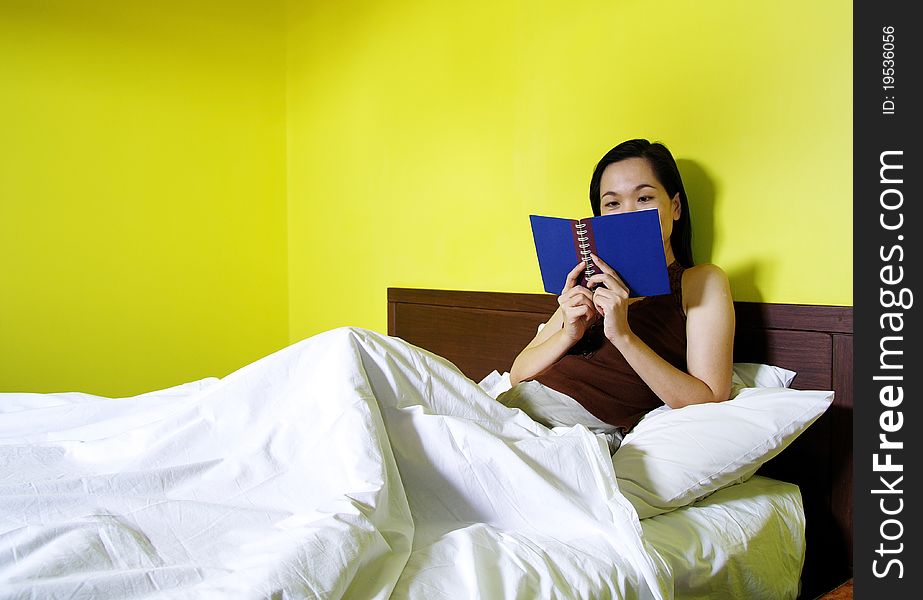 Woman reading a book in bedroom