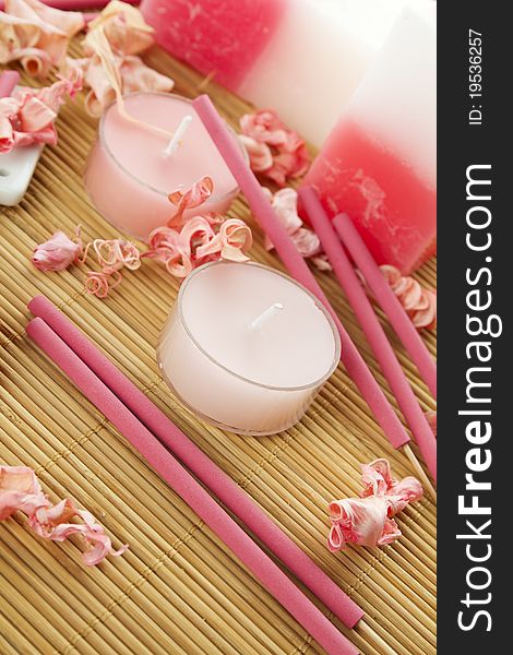 Spa treatment in bright pink and white palette, petals, candles, and arotatizirovannye sticks on a wooden bamboo rug. Spa treatment in bright pink and white palette, petals, candles, and arotatizirovannye sticks on a wooden bamboo rug