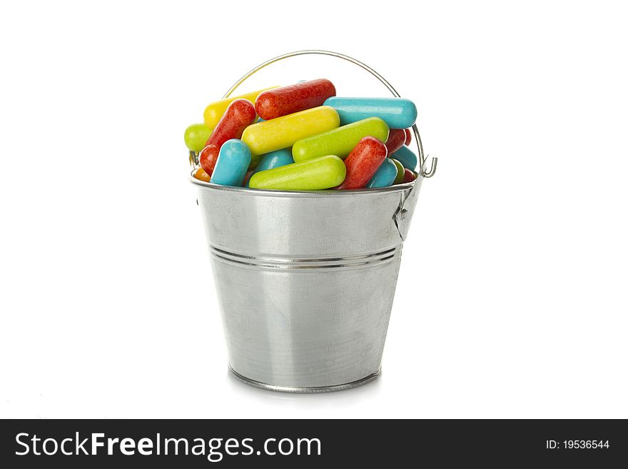 Lots of colorful flowers in a steel bucket. Isolated on white background. Lots of colorful flowers in a steel bucket. Isolated on white background