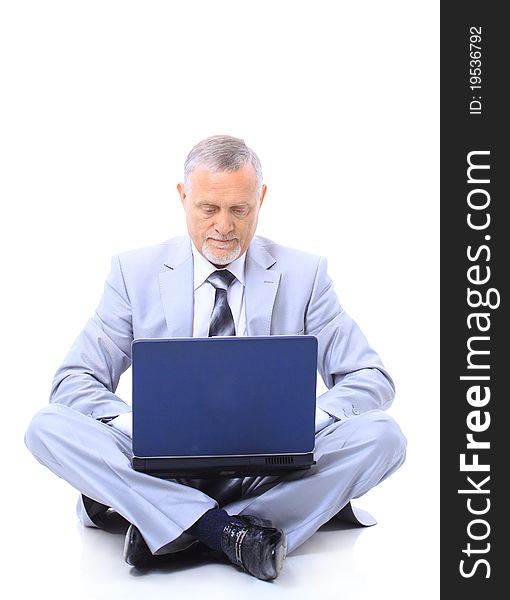 Executive sitting on the floor cross-legged with laptop