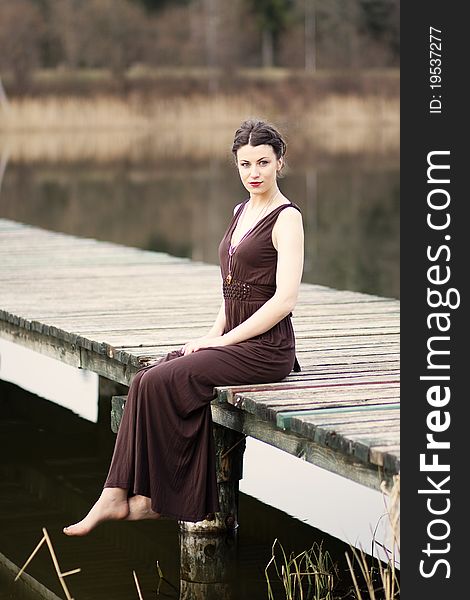 Young Woman Sitting On The Footbridge