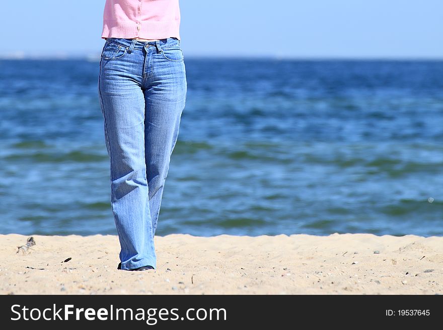 Legs of a young woman walking along the seacoast. Legs of a young woman walking along the seacoast