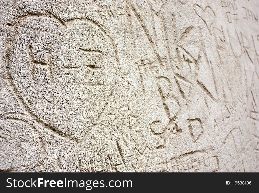 Detail of a wall engraved with love messages, pictures, letters, dates and names. Suitable as a background. Shot in Petrin, Prague.