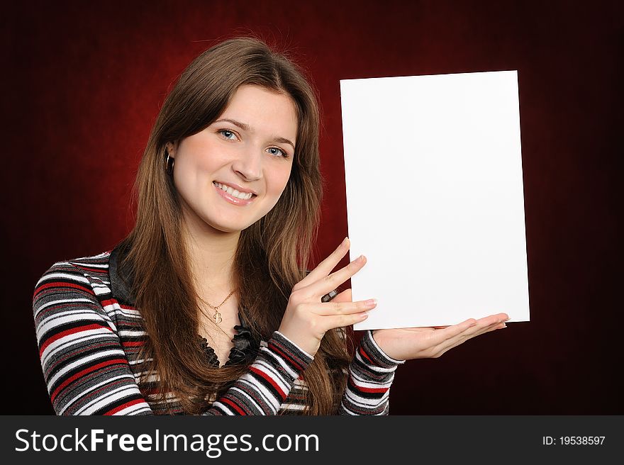 Young woman holding empty white board, on a red background