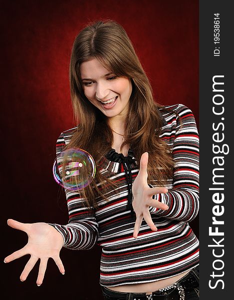 Young beautiful girl catch soap bubbles on red background. Young beautiful girl catch soap bubbles on red background