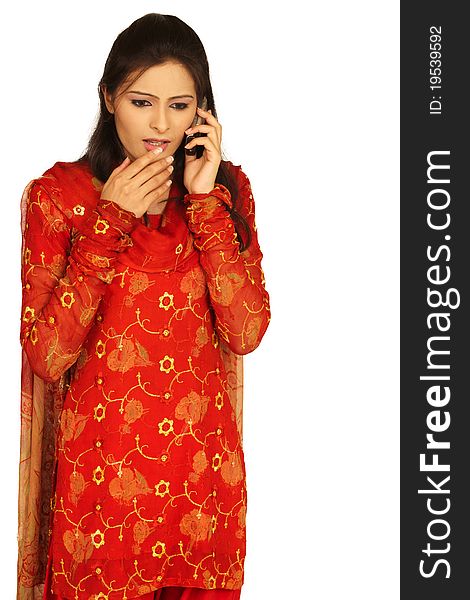 Surprise - A very surprised cute young Indian girl talking on mobile phone against white background