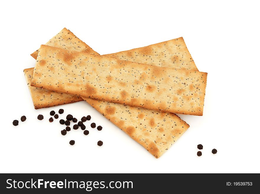 Salt and pepper crackers with loose peppercorns isolated over white background.