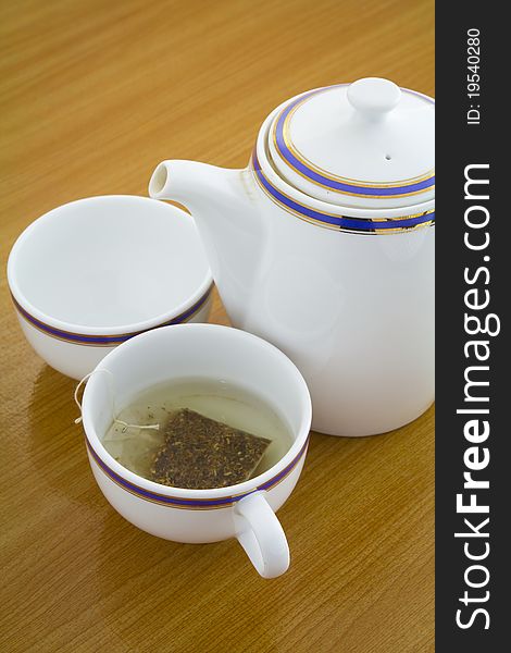 Cup of tea and teapot on wooden table. Cup of tea and teapot on wooden table