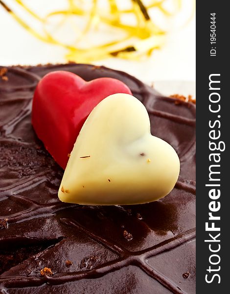 Two marzipan hearts on a chocolate icing cake
