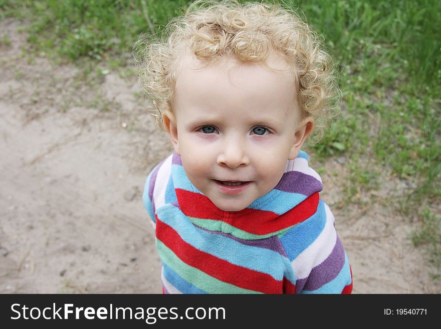 Portrait of little funny curly girl in striped blouse