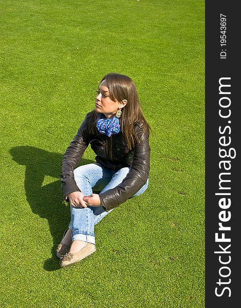 Girl sitting on a green lawn