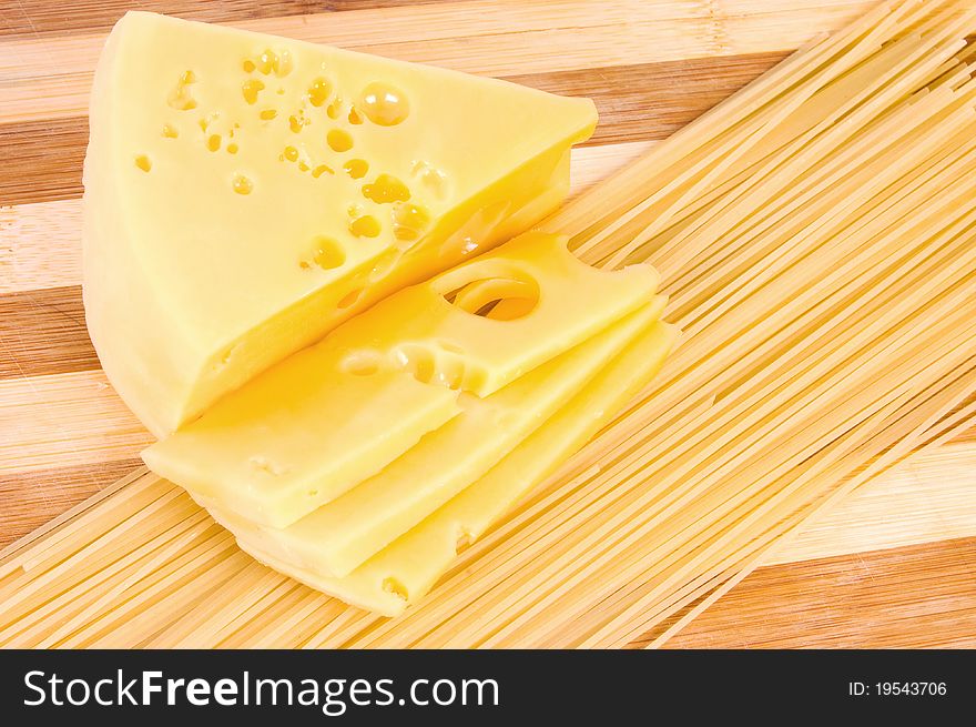 Close-up shot of italian food: cheese and spagetti on wooden board