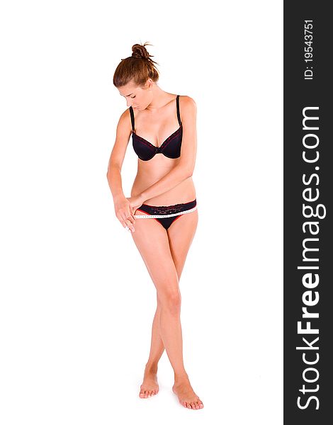 young Caucasian woman measuring her slim body