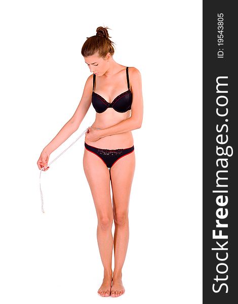 young Caucasian woman measuring her slim body