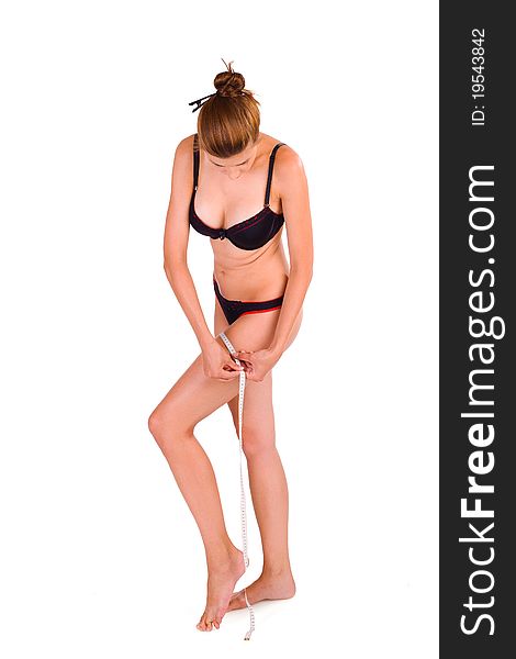 young Caucasian woman measuring her slim body