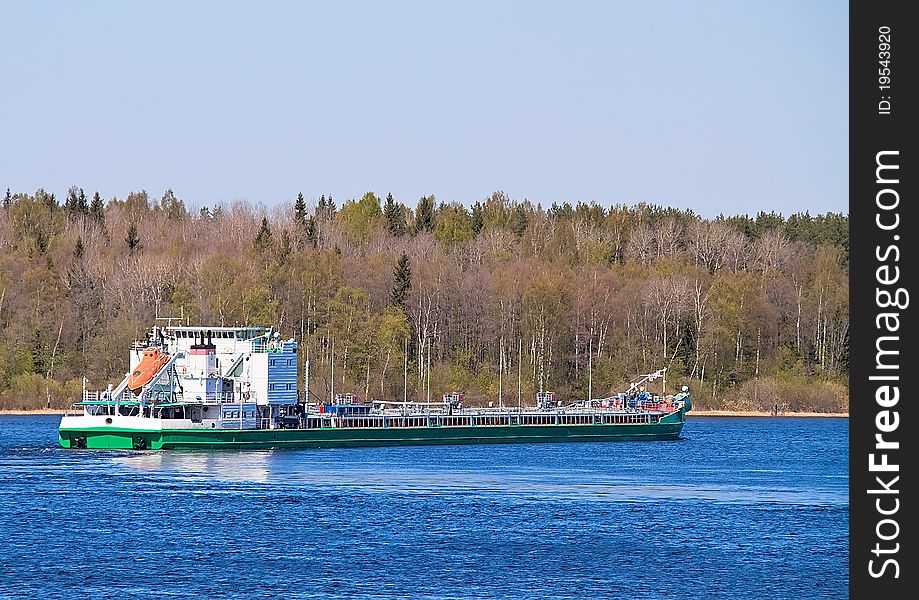 Barge on the river against the backdrop of the forest